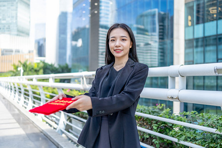 商务人像白天白领女性天桥手拿荣誉证书递出去摄影图配图