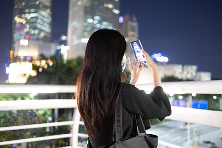 商务人像夜晚职场女性天桥拿手机拍照摄影图配图