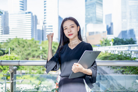商务人像白天商务人像拿着文件夹加油打气摄影图配图
