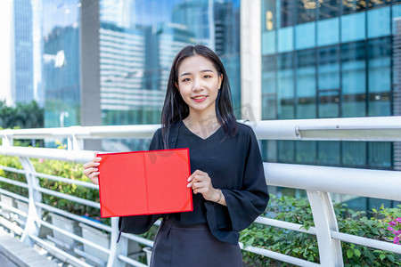 商务人像白天白领女性人行天桥手拿荣誉证书摄影图配图