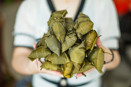 手捧包好的粽子端午节一个人室内手捧摄影图配图