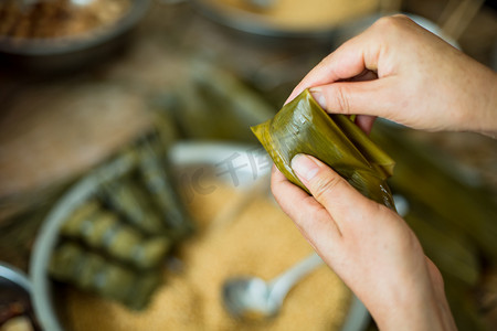 手包粽子端午节一个人室内手工摄影图配图