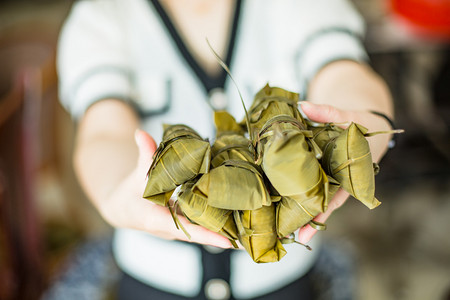 手捧包好的粽子端午节一个人室内无摄影图配图