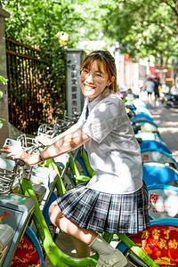 人像夏日美女路边骑自行车微笑摄影图配图
