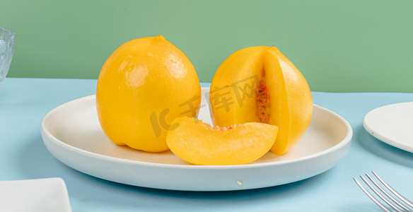黄桃摄影照片_清新夏季水果白天一盘黄桃室内切开果实摄影图配图