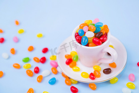 糖果背景图摄影照片_糖果背景实物拍摄咖啡杯里的糖果美食餐饮摄影图配图