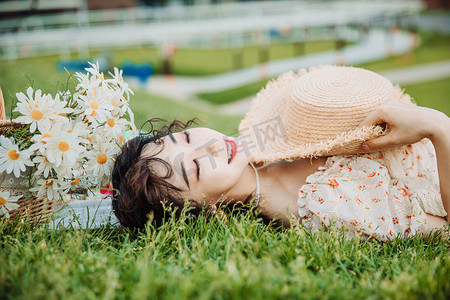 美女眼睛摄影照片_野餐露营白天躺在草地上的美女草地闭眼睛摄影图配图