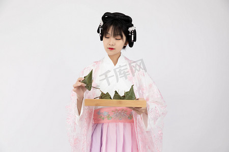 粽子摄影照片_端午节白天古装少女室内美食粽子摄影图配图