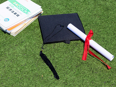 学士帽证书白天毕业证书校园草地毕业摄影图配图