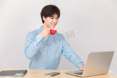 商务人像白天职业男孩办公室喝咖啡看电脑摄影图配图