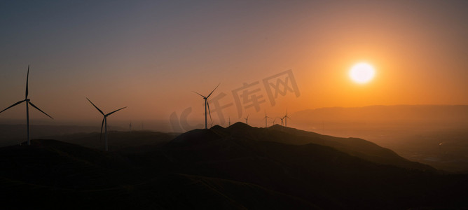 风车发电摄影照片_新能源发电傍晚风车剪影山峰夕阳余晖摄影图配图