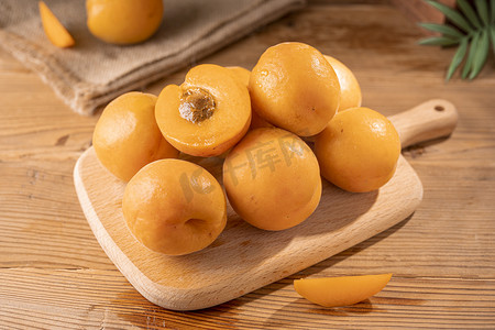 新水果摄影照片_夏天砧板上的新鲜黄杏水果摄影图配图