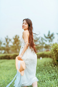 长裙竹荪摄影照片_文艺夏天白天穿着白色长裙的美女户外奔跑摄影图配图