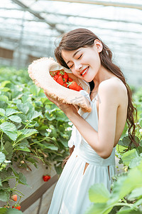 夏天摄影照片_夏天文艺白天捧着草莓的美女户外微笑摄影图配图