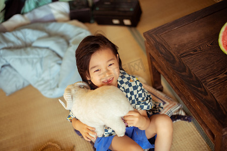 夏日儿童白天长发男孩室内开心的抱着小羊摄影图配图