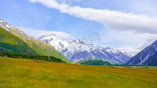 草原雪山摄影照片_雪山白云草原正午草地户外风景摄影图配图