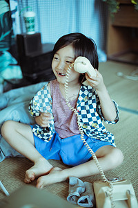 夏日儿童白天爱笑的男孩室内开心的拿着电话摄影图配图
