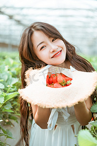 摄影照片_夏天文艺白天摘草莓的美女采摘园捧着草莓摄影图配图