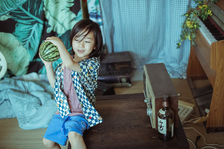 夏日儿童白天长发男孩室内开心抱着西瓜摄影图配图