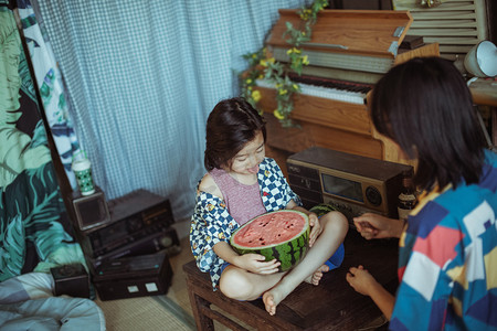 六一儿童节游园海报摄影照片_夏日亲子白天母子两人室内抱着西瓜摄影图配图