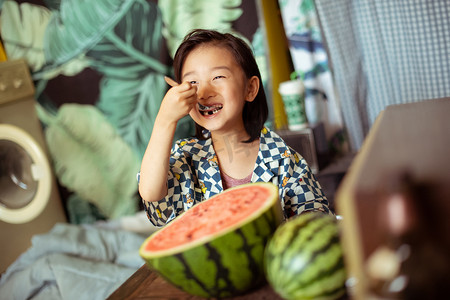 夏日儿童白天一个男孩室内开心吃西瓜摄影图配图