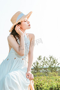 文艺夏天白天穿着长裙的美女户外听风摄影图配图