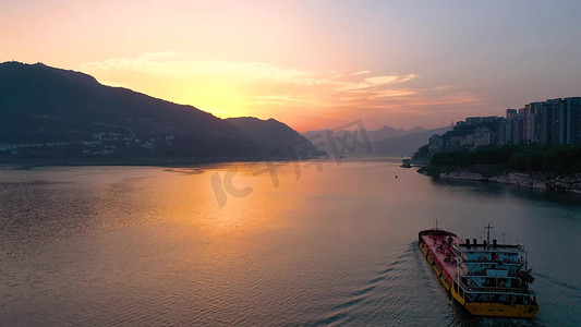 江面摄影照片_夕阳江面上行驶的货运邮轮风景