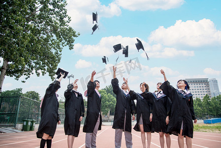 毕业摄影照片_人像白天大学生操场扔学士帽摄影图配图