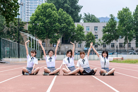 毕业摄影照片_人像白天五个大学女生操场上坐着摄影图配图