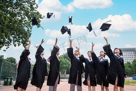 操场摄影照片_人像白天大学生操场跑道扔学士帽摄影图配图