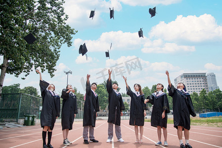 学士学士摄影照片_人像白天七个大学生操场扔学士帽摄影图配图