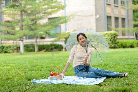 校园友情摄影照片_人像白天美女草地打伞摄影图配图