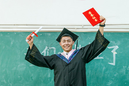 毕业黑板摄影照片_人像白天大学男生黑板毕业摄影图配图