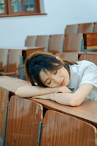 美女睡觉摄影照片_人像白天学生教室睡觉摄影图配图