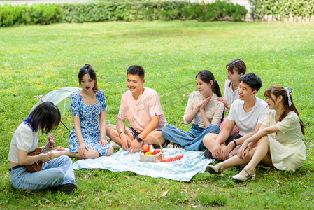 朝鲜族聚餐摄影照片_人像白天七个大学生草地野餐摄影图配图