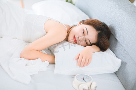 睡眠摄影照片_人物形象早晨美女床上休息摄影图配图