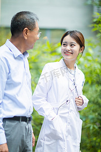 走路溅起水花摄影照片_老年健康白天老人和女医生户外走路交流摄影图配图