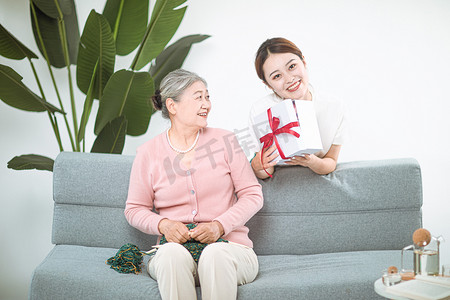 家庭和谐白天母女二人家里送礼物摄影图配图