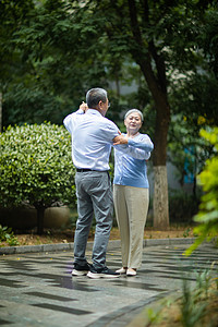老年迪斯科摄影照片_老年生活白天一对老夫妇户外跳交际舞摄影图配图