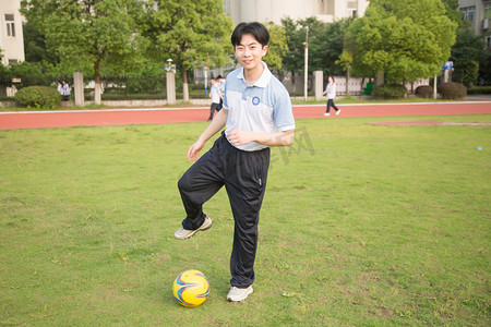 学生比赛摄影照片_足球球场踢球比赛草地摄影图配图