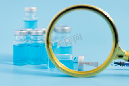 蓝色疫苗摄影照片_疫苗医疗微缩创意蓝色背景摄影图配图