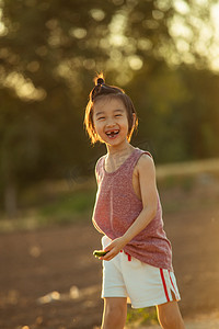 夕阳人物摄影照片_夏日儿童人像夕阳长发小男孩麦田童真的笑摄影图配图