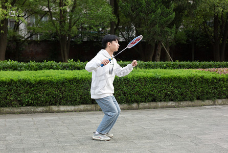 运动男性羽毛球拍球写真摄影图配图