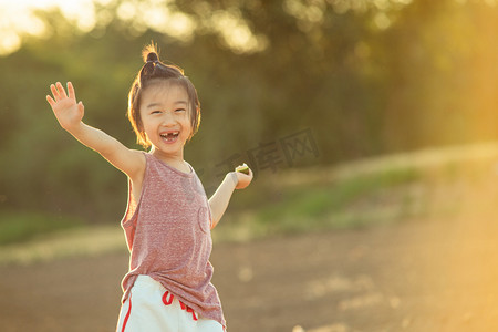 活泼摄影照片_夏日儿童人像夕阳可爱的男孩麦田开心的玩摄影图配图