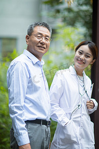 礼敬老人情浓重阳摄影照片_老年健康白天老人和女医生户外走路交谈摄影图配图