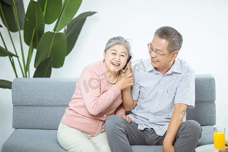 情人节人物摄影照片_家庭和谐白天夫妇客厅打电话摄影图配图