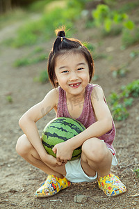 林间小路摄影照片_夏日儿童人像白天小男孩林间小路开心的怀抱大西瓜摄影图配图