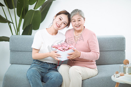 重阳节摄影照片_家庭和谐白天母女考虑送礼物摄影图配图