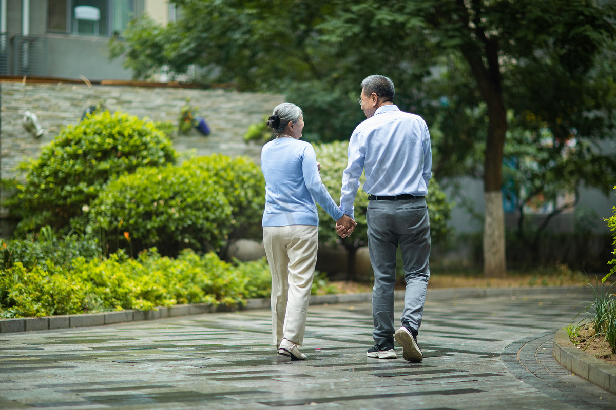 老年夫妻并肩在公园散步高清摄影大图-千库网