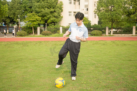 足球学生足球摄影照片_足球球场运动员踢球运动摄影图配图